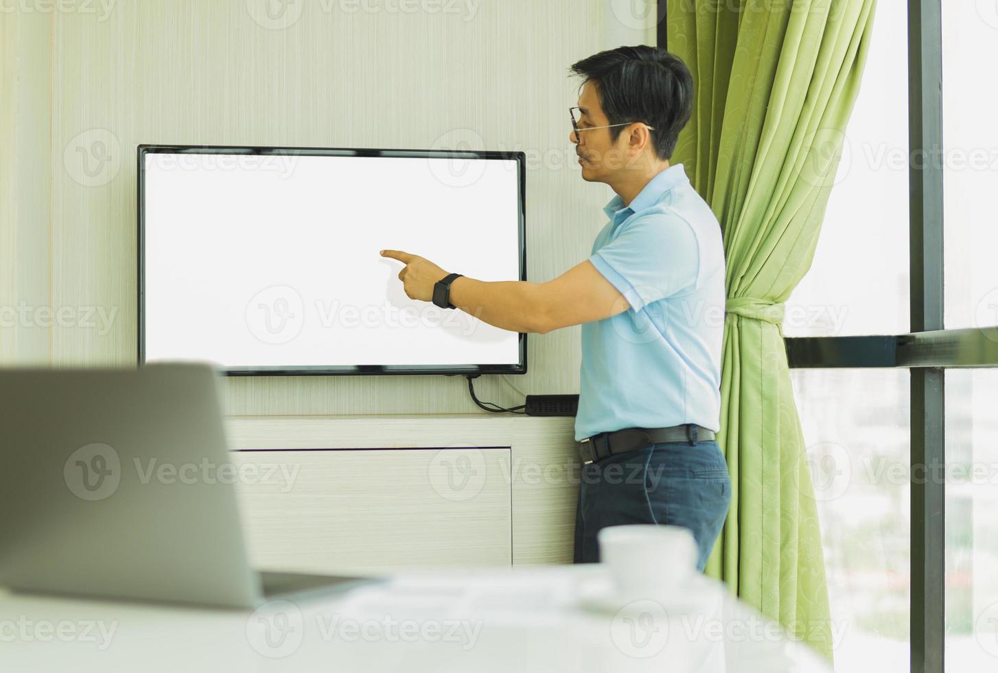 presença de empresário na sala de conferências com a mão apontando para a tela foto