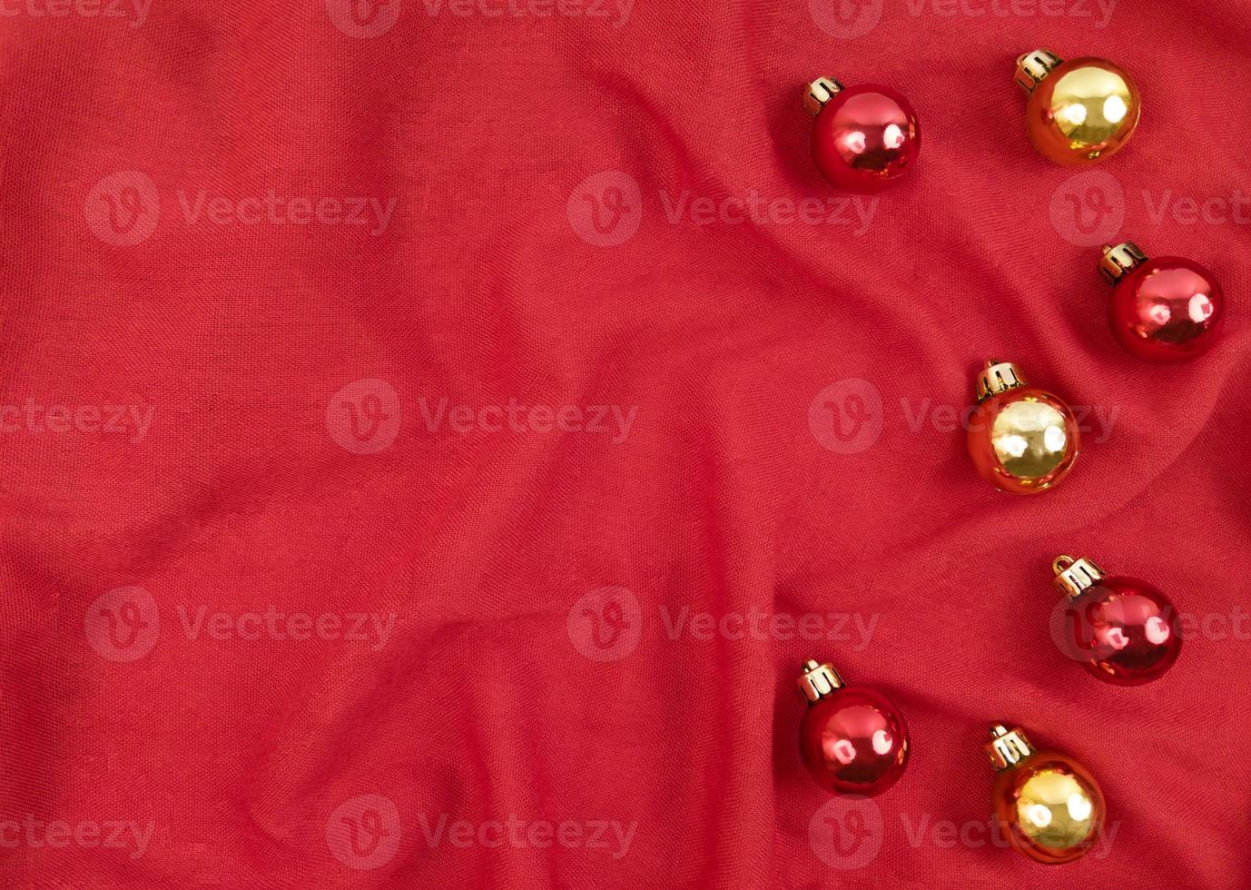 bolas de natal vermelhas e douradas em um fundo vermelho de tecido foto