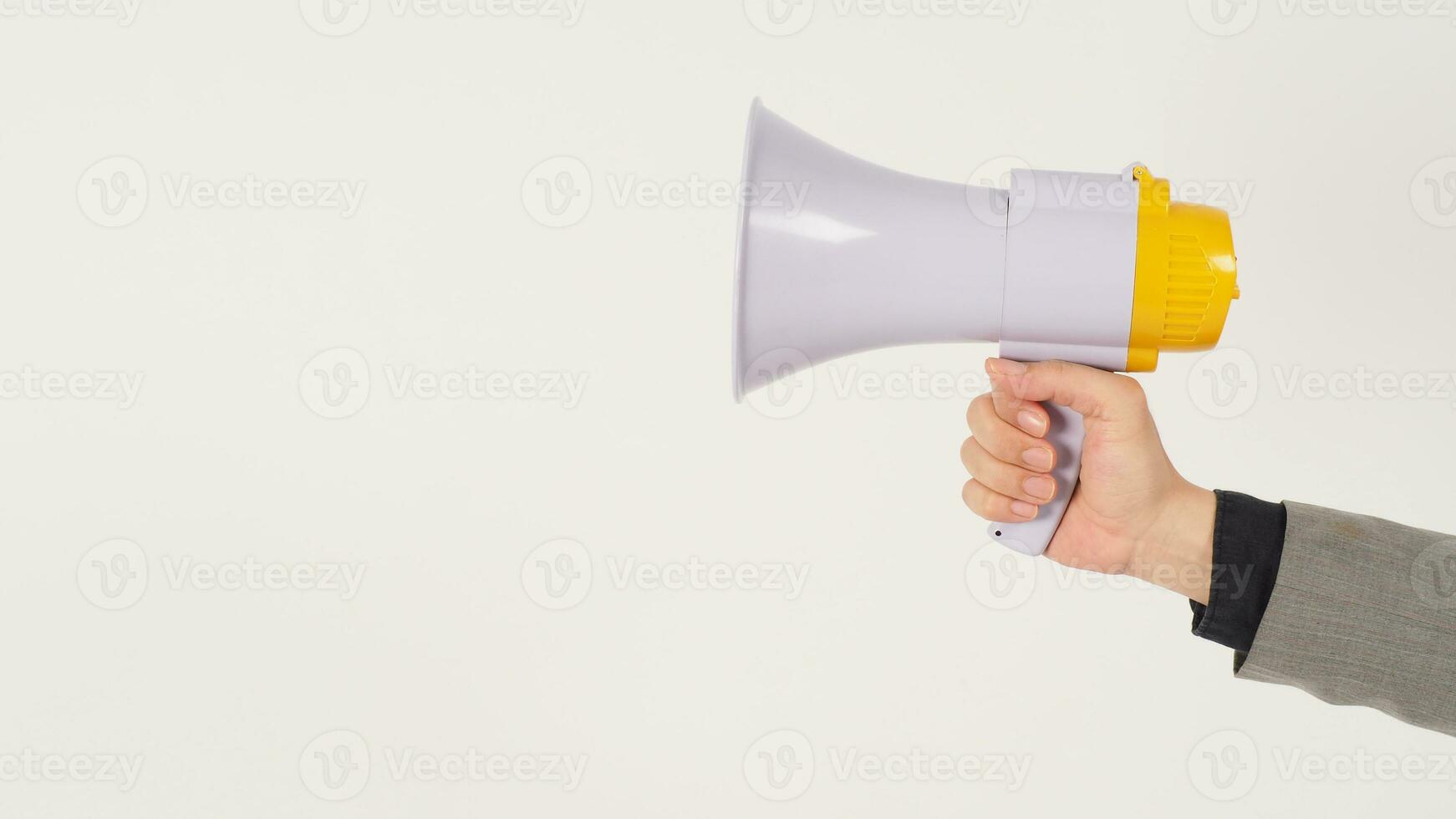 a mão do homem está segurando um megafone e veste um terno cinza sobre fundo branco. foto