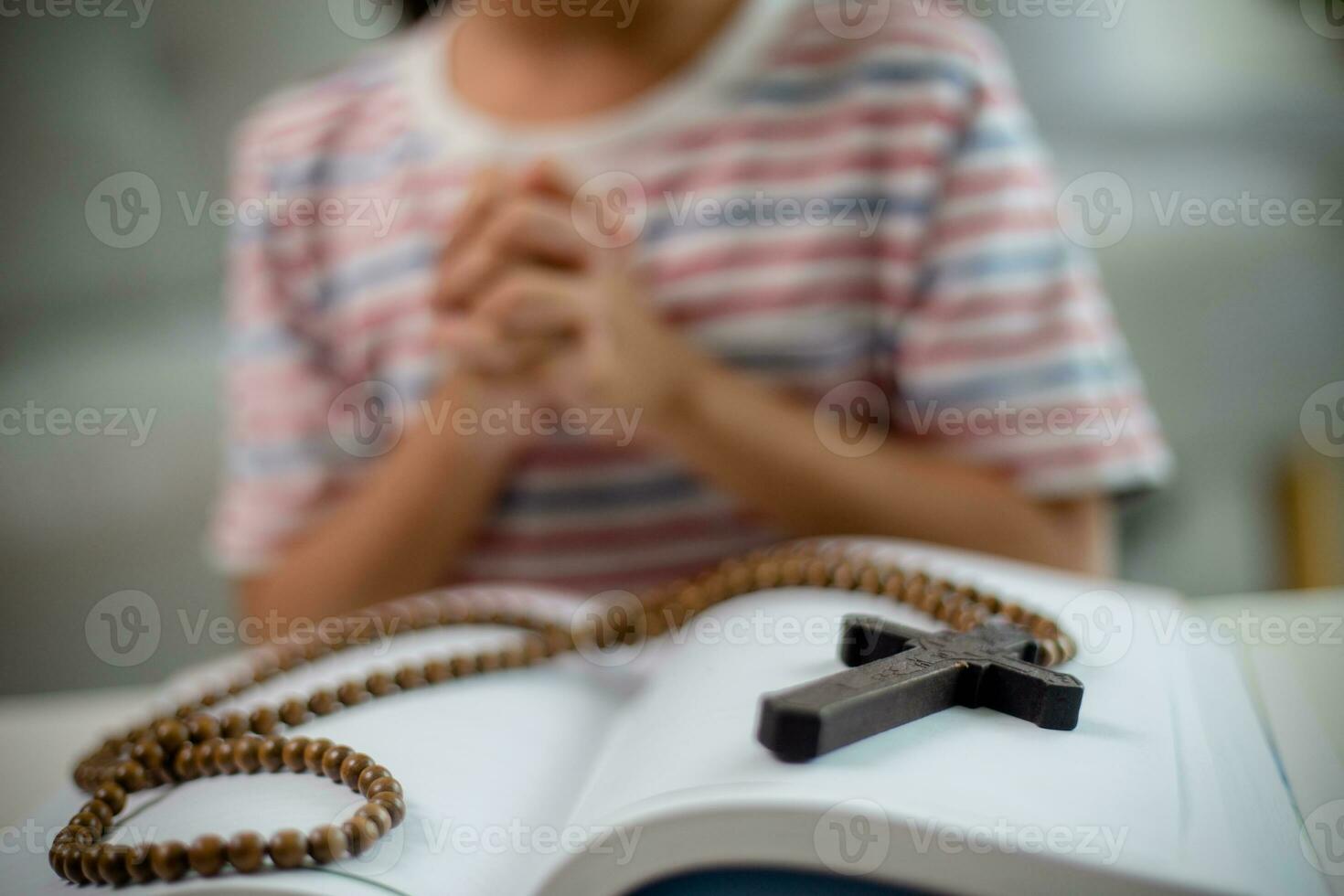 cristão conceito. pequeno ásia menina Rezar retendo a Cruz. conceitos do ter esperança, fé, cristandade, religião, foto