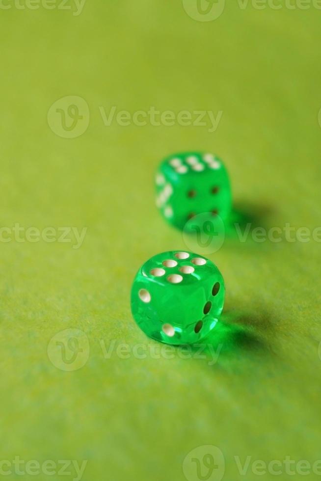 uma macro monocromática vibrante com profundidade de campo sobre dois dados de jogo de vidro verde com dois número seis da sorte em fundo verde foto