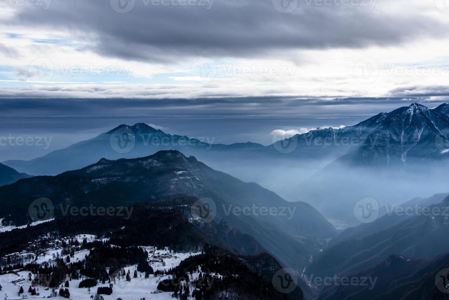 picos alpinos cobertos de neve nas nuvens cinco foto