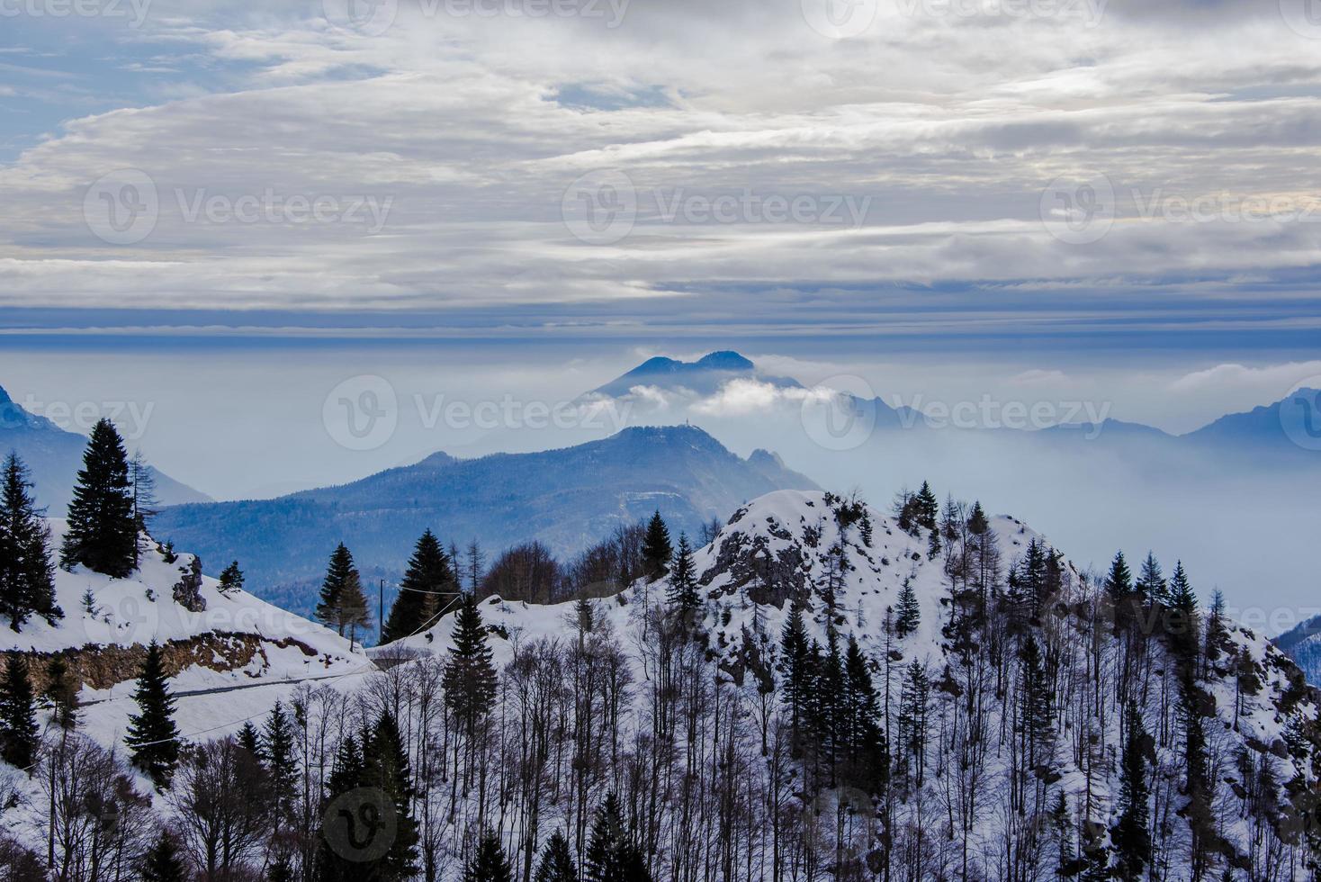 picos alpinos cobertos de neve nas nuvens um foto