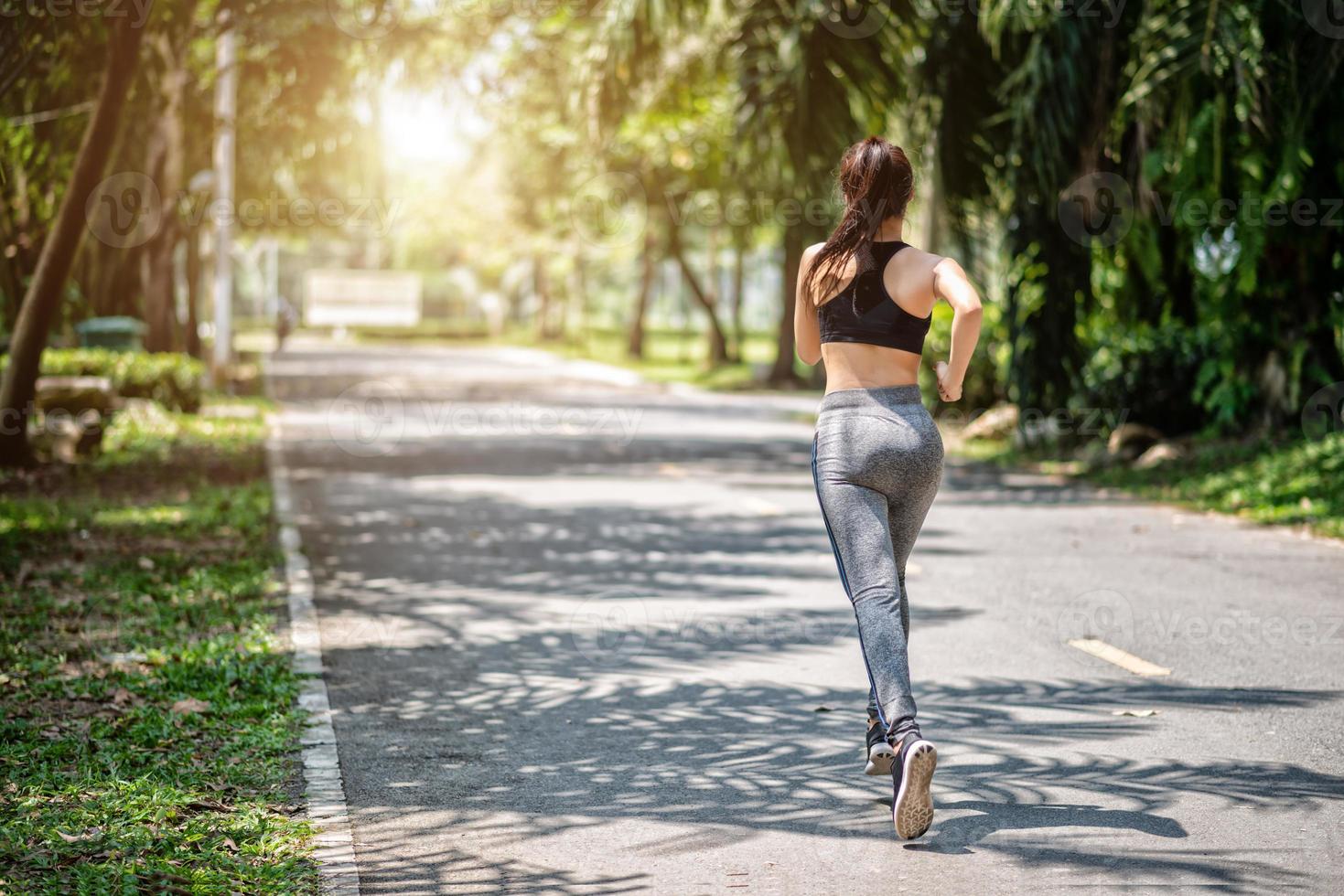 Mulher bonita esportiva correndo no parque foto