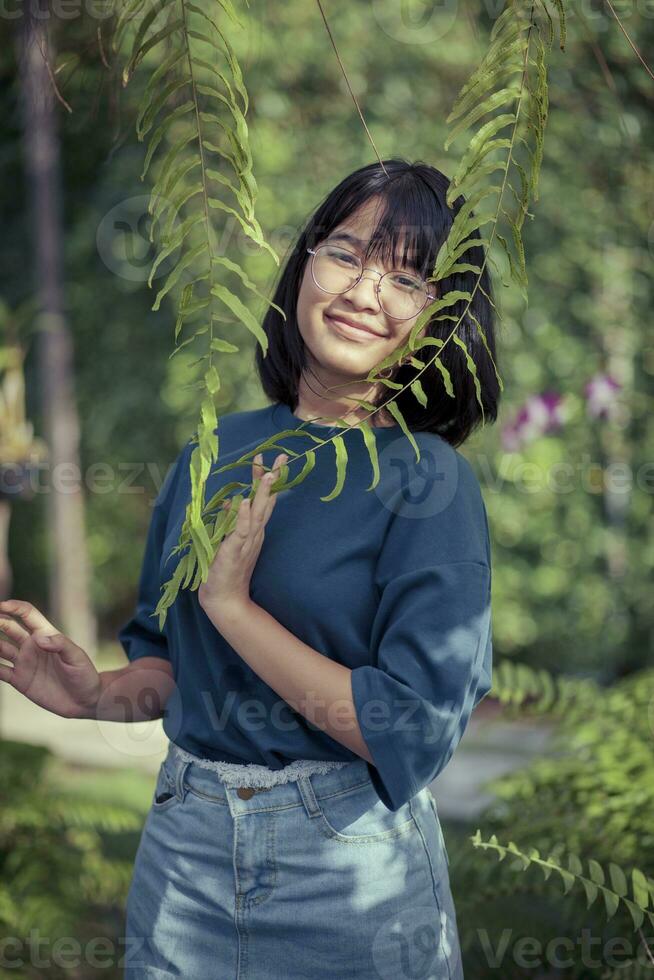ásia adolescente relaxante dentro samambaia botânico jardim foto