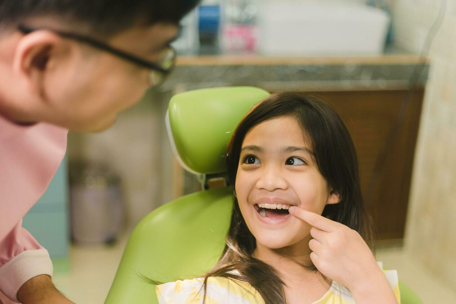 fofa Asain menina durante dental tratamento às moderno clínica foto