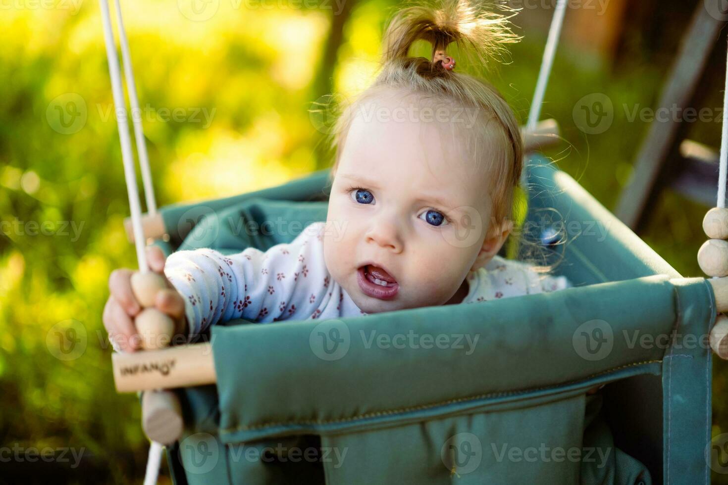 fofa pequeno menina dentro a balanço. bebê balanço em a árvore dentro a jardim. infantil jogando dentro a quintal foto