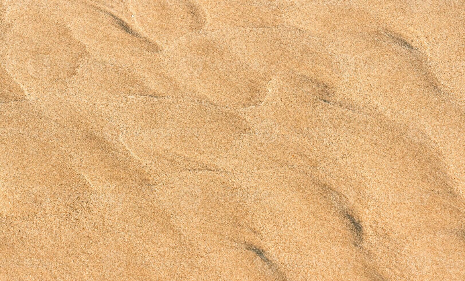 areia de praia textura fundo dentro verão, topo Visão Castanho arenoso rude superfície com onda ondulação do mar água com cópia de espaço para verão bandeira desenho, natural areia pedra de a mar foto