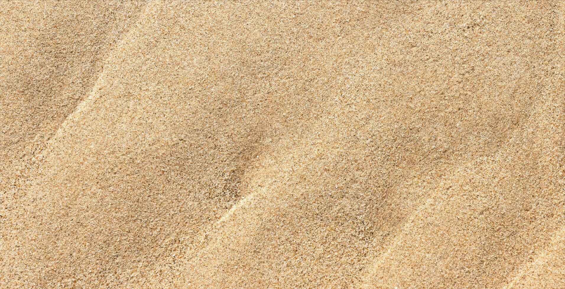 areia de praia textura fundo dentro verão, topo Visão Castanho arenoso rude superfície com onda ondulação do mar água com cópia de espaço para verão bandeira desenho, natural areia pedra de a mar foto