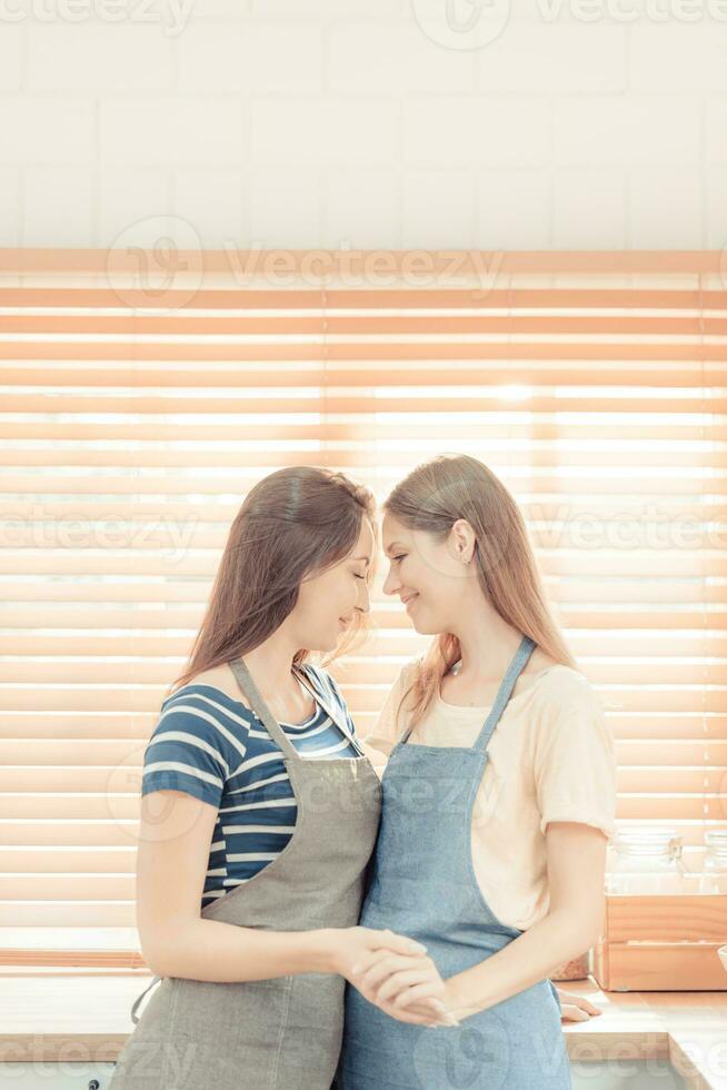 lésbica casal juntos dentro de casa conceito. lésbica dentro a cozinha. jovem mulheres estão dentro uma mútuo lésbica amor relação. lgbt conceito. caloroso tom. foto
