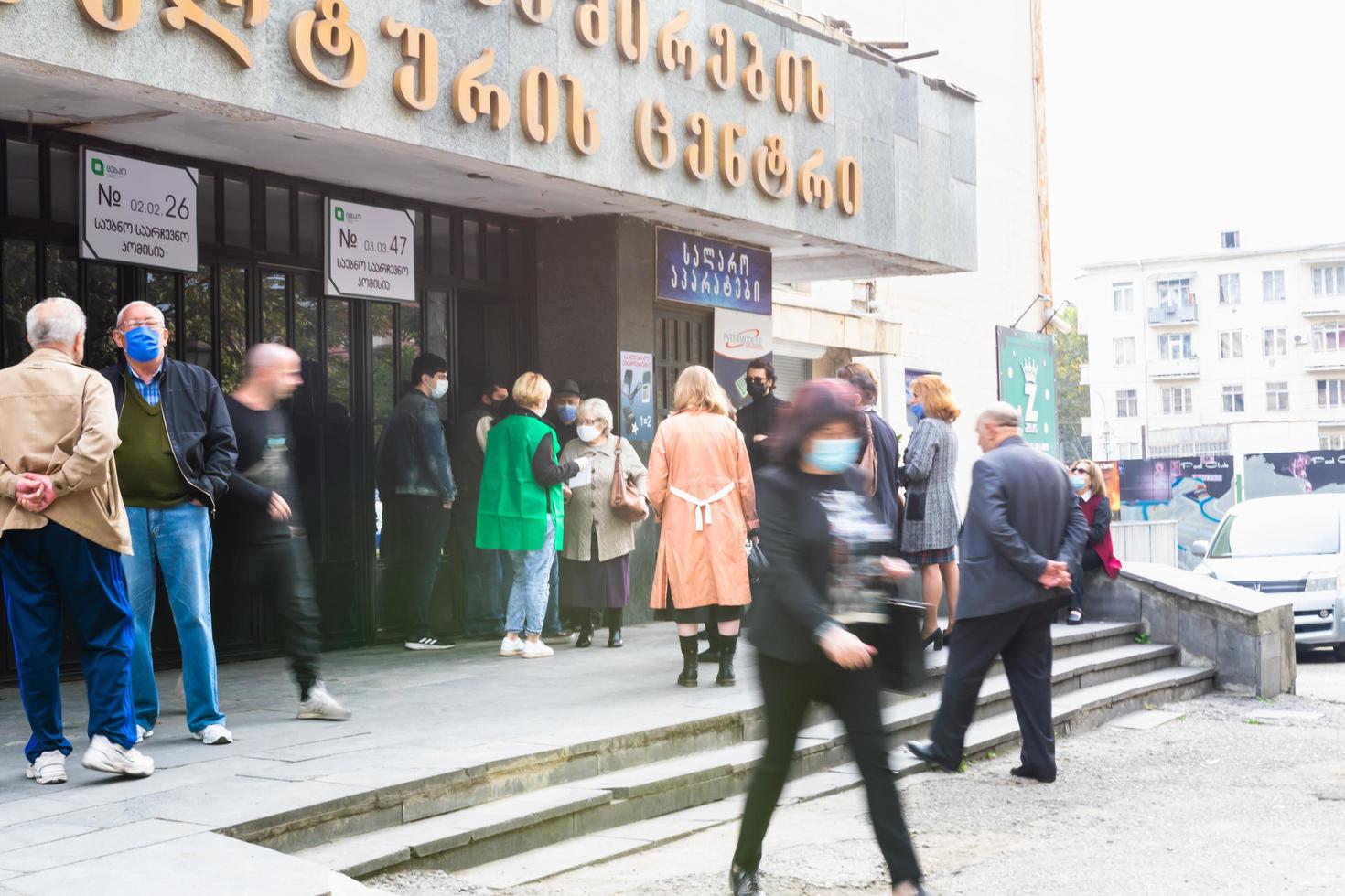 tbilisi, república da georgia 2020- segurança verifica a identidade do cidadão fora da estação de votação do centro comunitário do sindicato do trabalho 26 em saburtalo foto