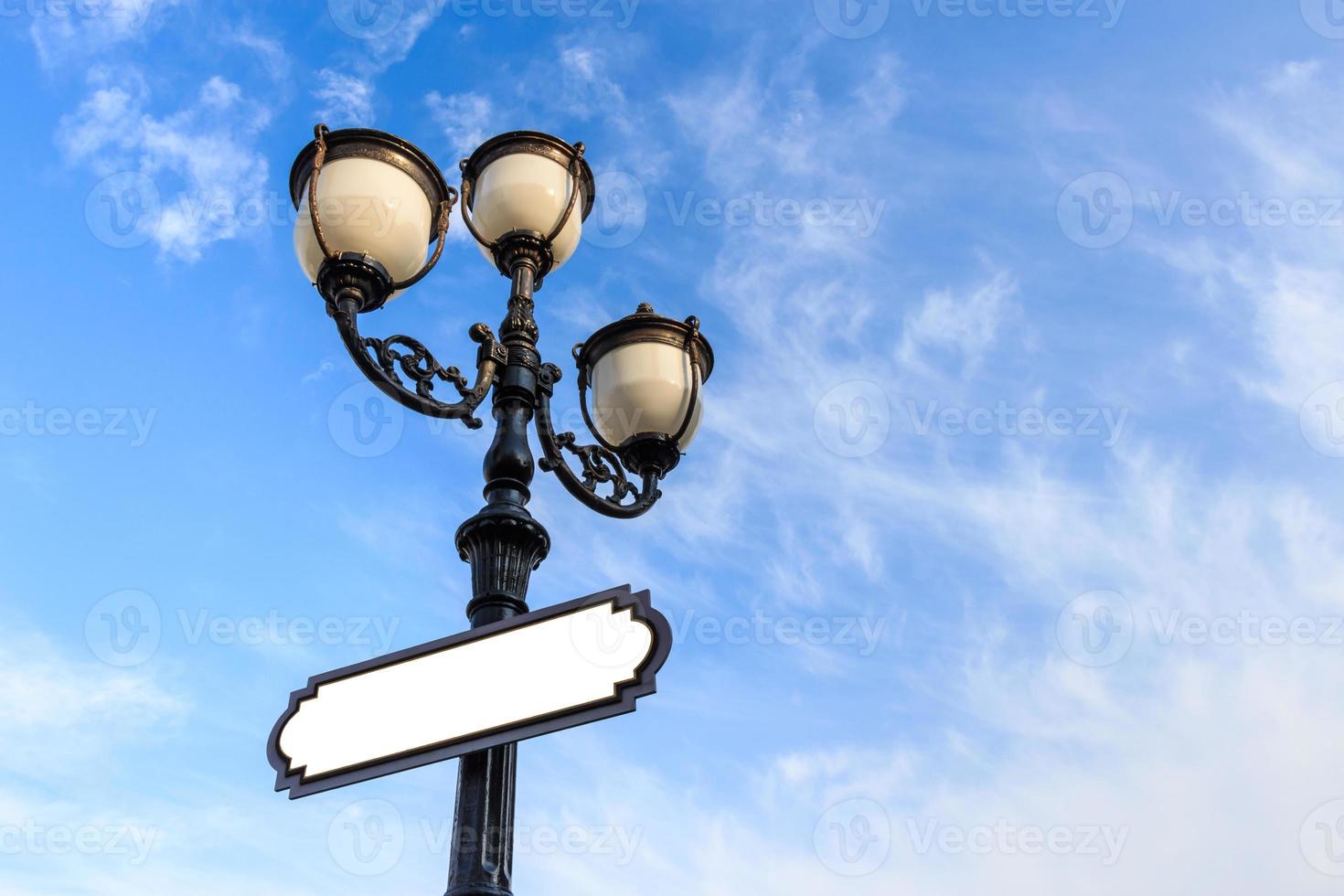 lâmpada de rua e área em branco a bordo para mensagem de preenchimento e céu azul foto