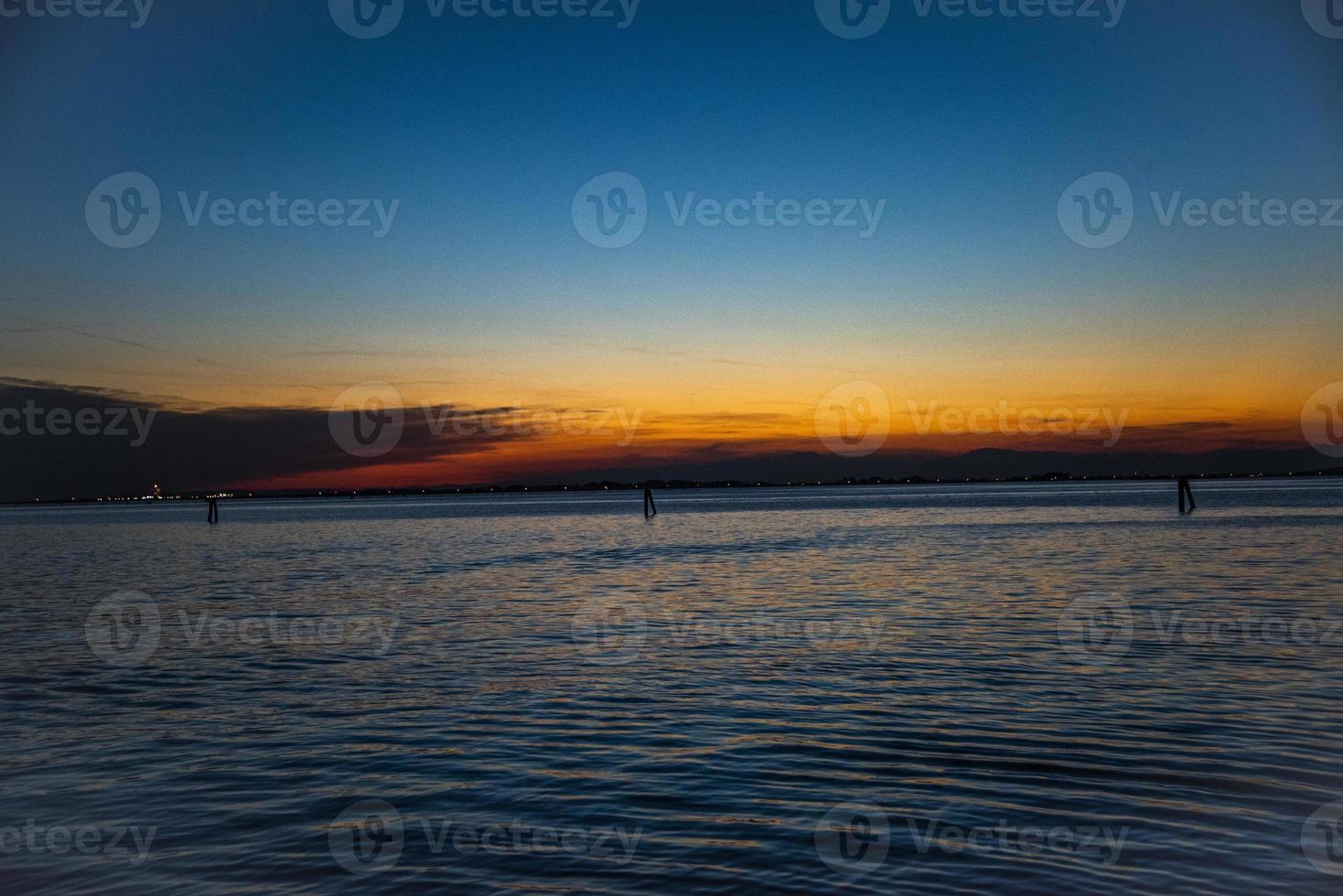 pôr do sol sobre a lagoa veneziana foto