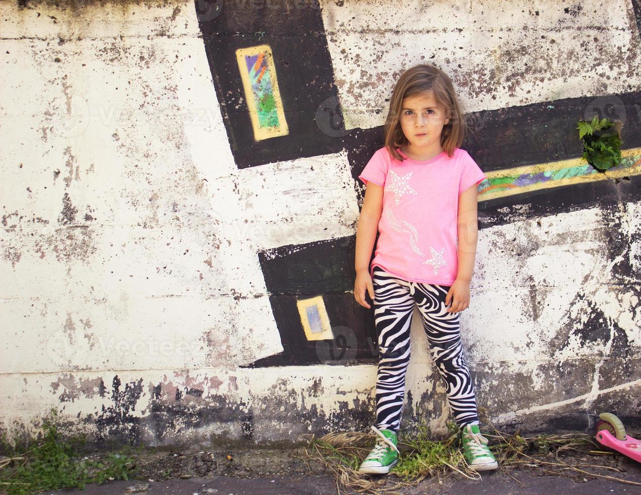 garotinha em frente a parede de grafite foto