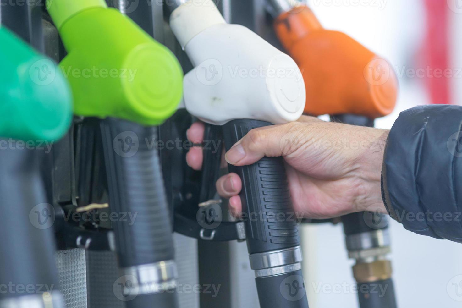 bicos da bomba de combustível para diferentes tipos de combustível em um posto de gasolina foto