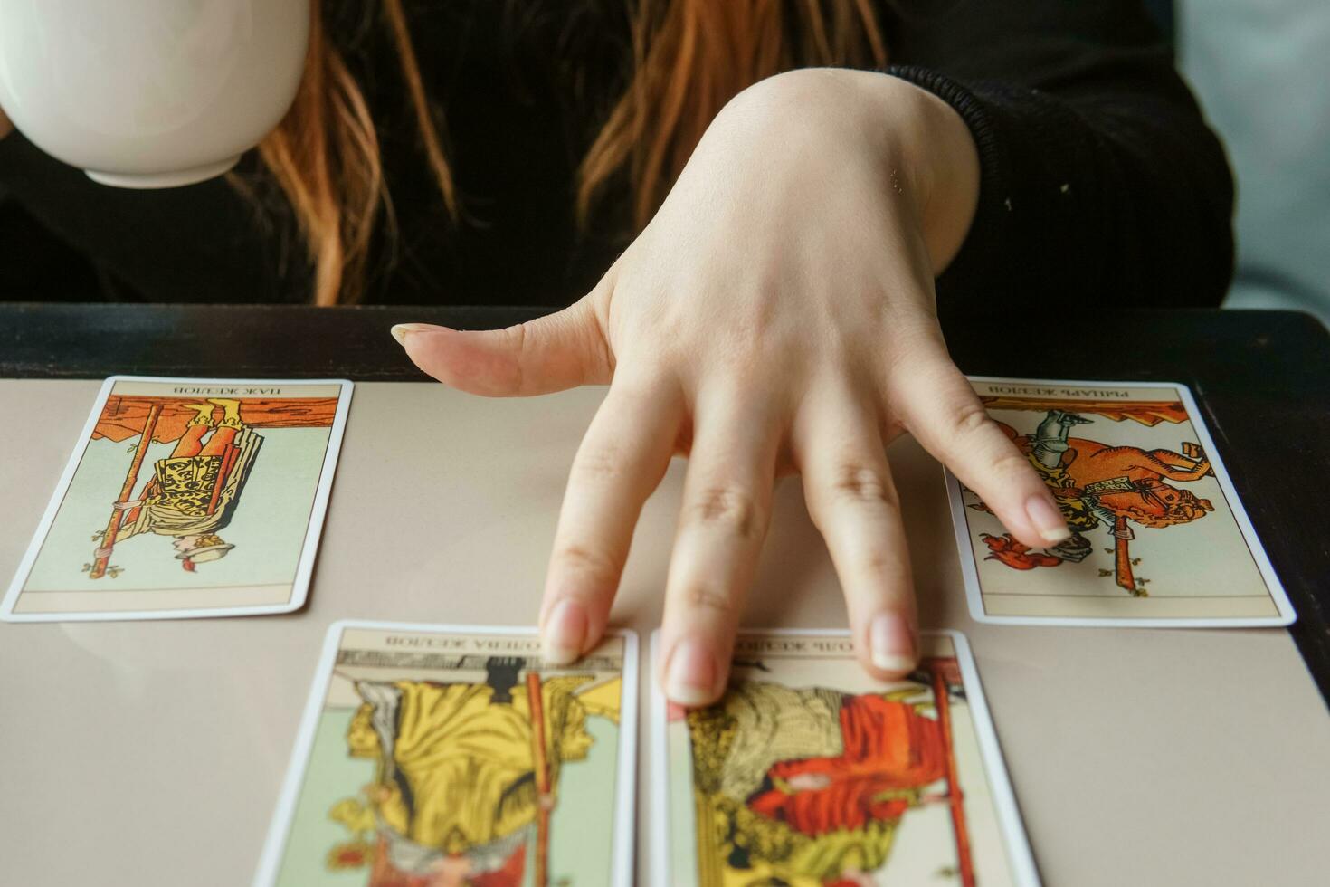tver, Rússia - fevereiro 11, 2023. tarot cartões, tarot cartão adivinhação, esotérico fundo. uma mulher faz uma disposição em a cartões às a mesa. adivinhação, previsões em tarot cartões. foto