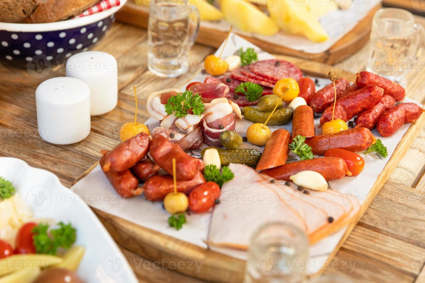 linguiça com queijo e pepino fermentado, salgadinhos com vodka na mesa foto