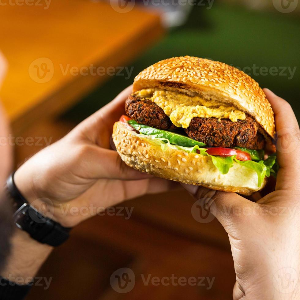 homem segurando hambúrguer vegetariano vegetariano foto