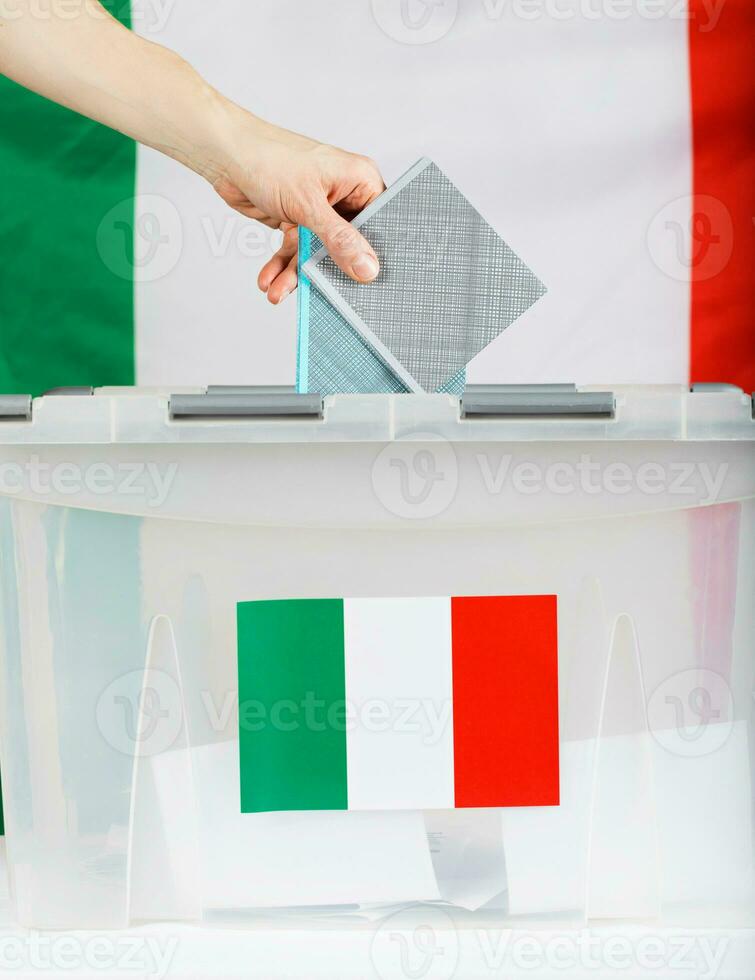 fêmea mão mantém votação sobre votação caixa. italiano bandeira dentro a fundo. foto
