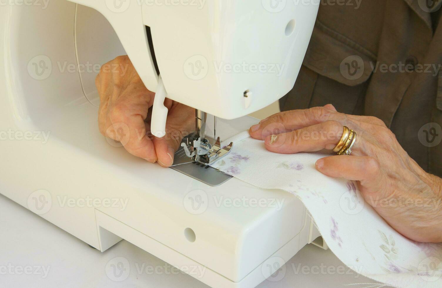 a velho cansado mulher quem é trabalhando em uma de costura máquina foto