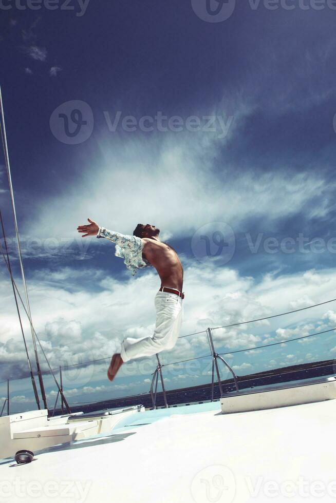 jovem navegando seu barco em mar aberto foto