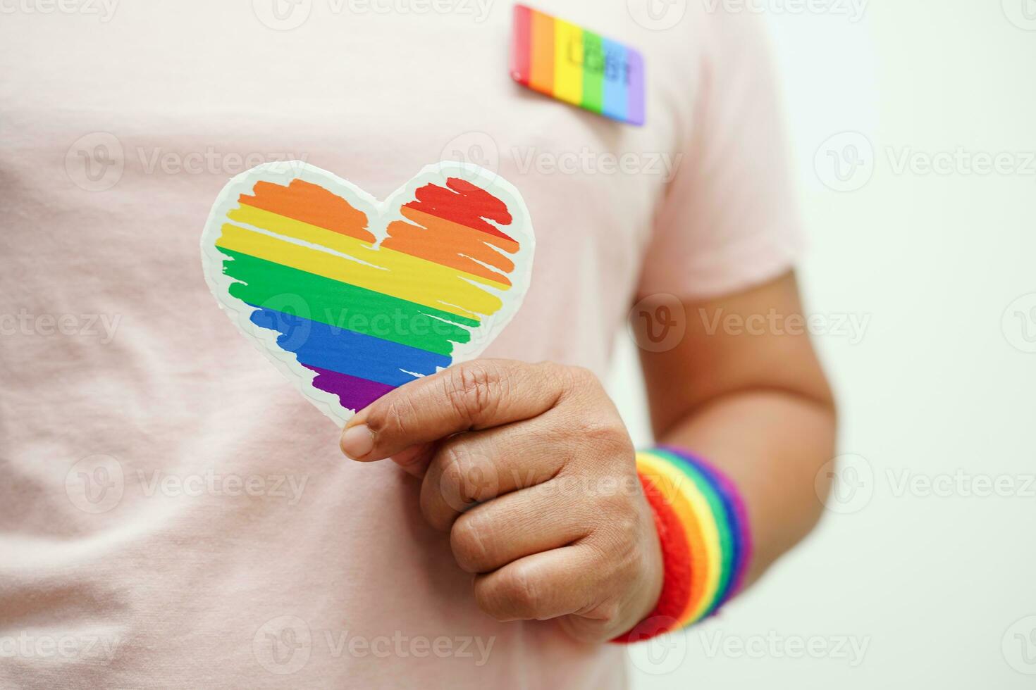 ásia mulher segurando vermelho coração com arco Iris bandeira, lgbt símbolo direitos e gênero igualdade, lgbt orgulho mês dentro junho. foto