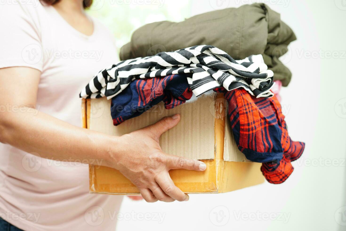 doações de roupas em caixa de papelão para voluntário. foto