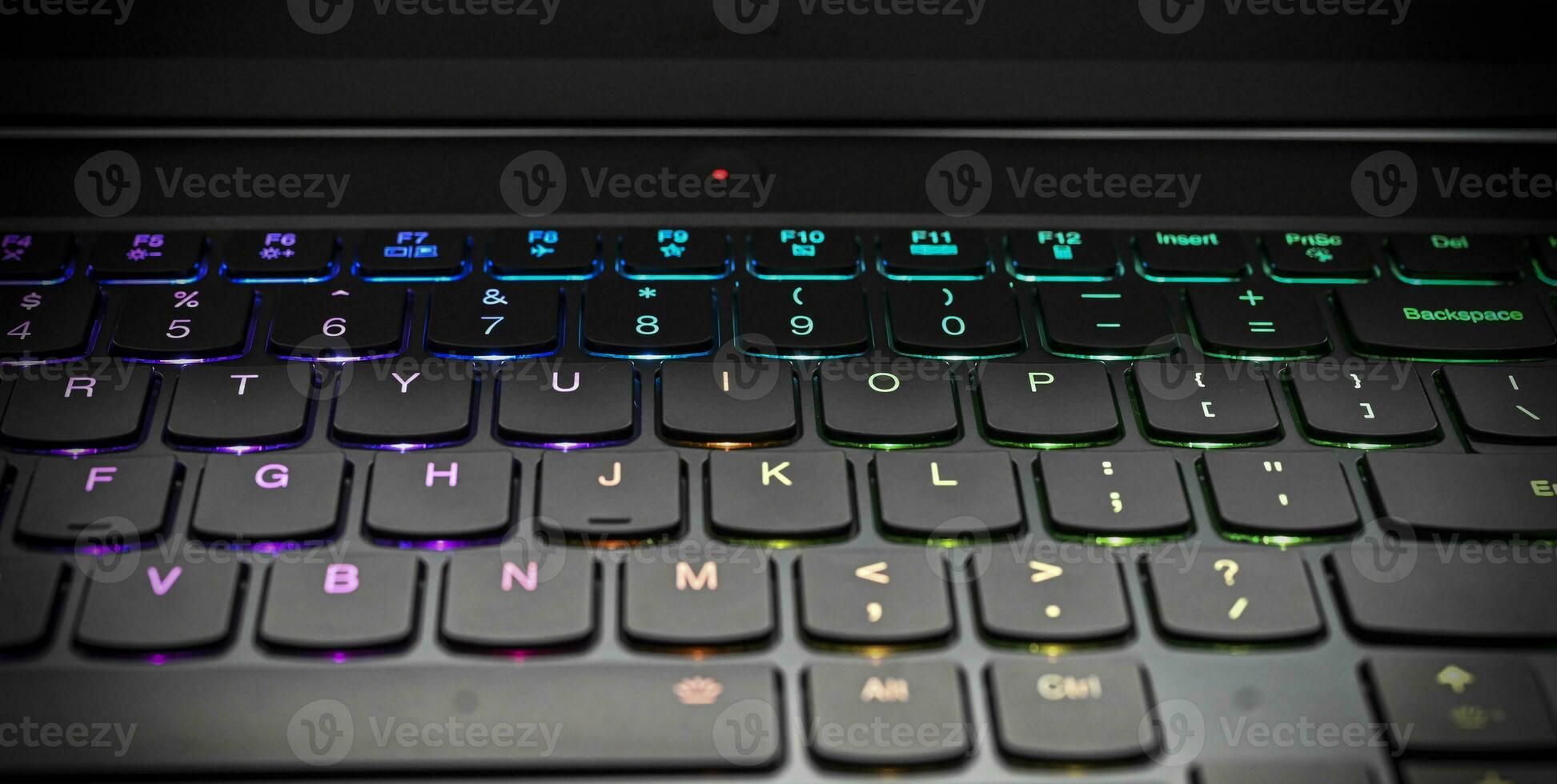 uma fechar-se Veja do uma Preto teclado com retroiluminado chaves dentro diferente cores foto