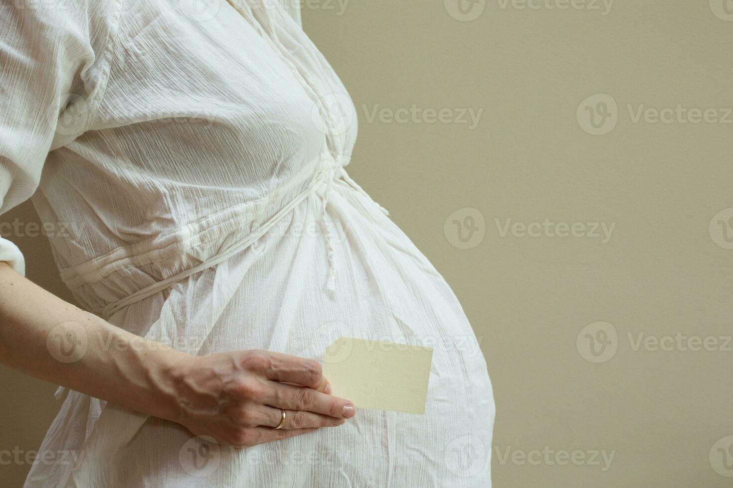 uma cartão com livre ritmo dentro a mão do uma grávida mulher foto