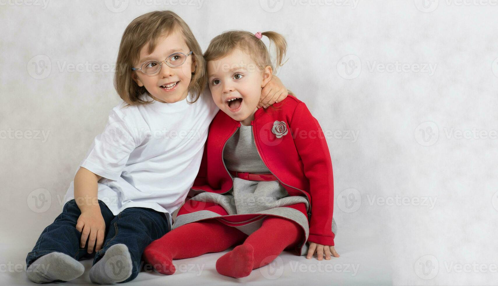 Garoto do cinco anos e menina do 2 anos estão sentado junto. foto