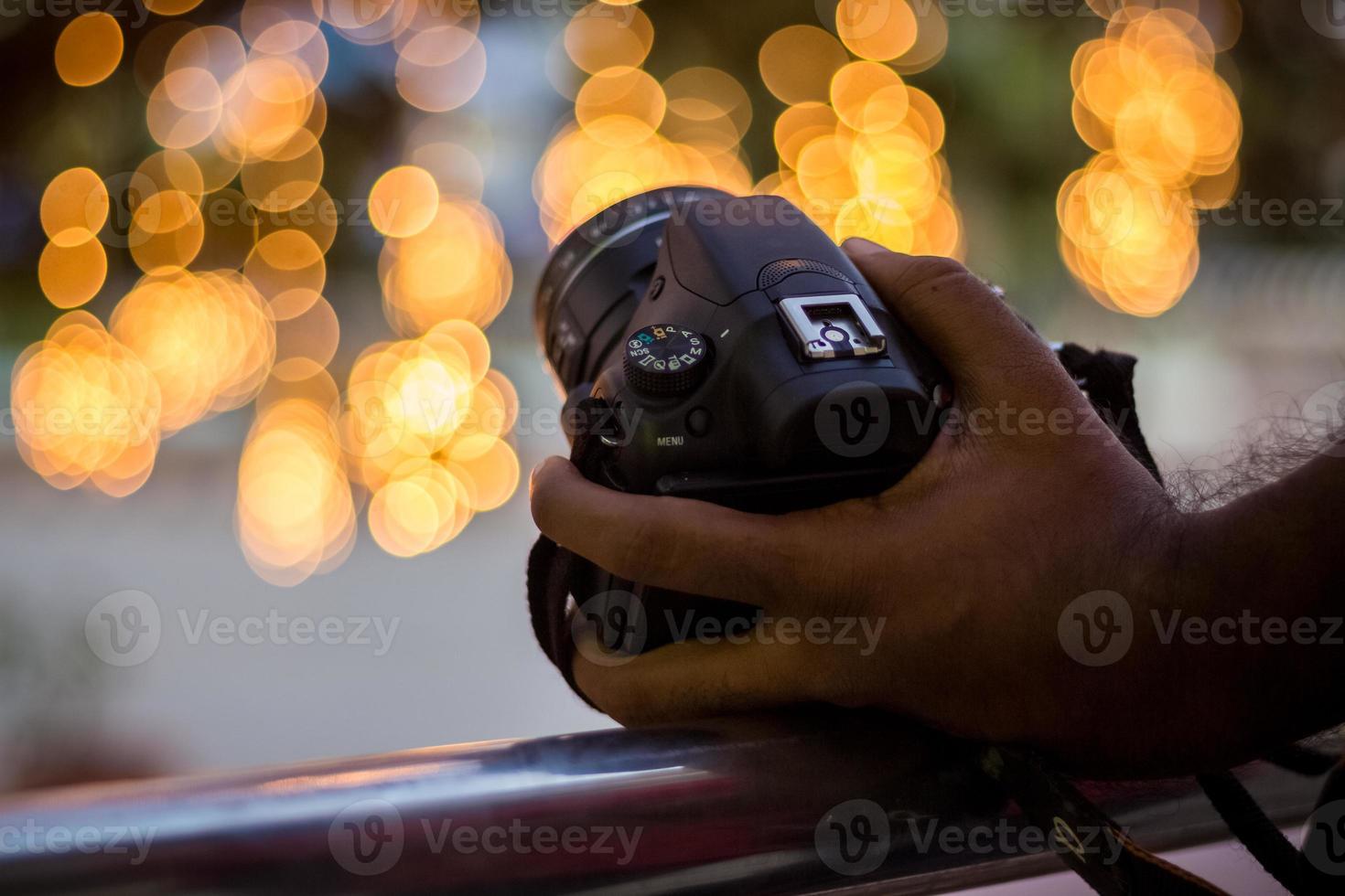 câmera dslr no fundo bokeh câmera dslr preta com luzes bokeh foto e câmera luzes da cidade