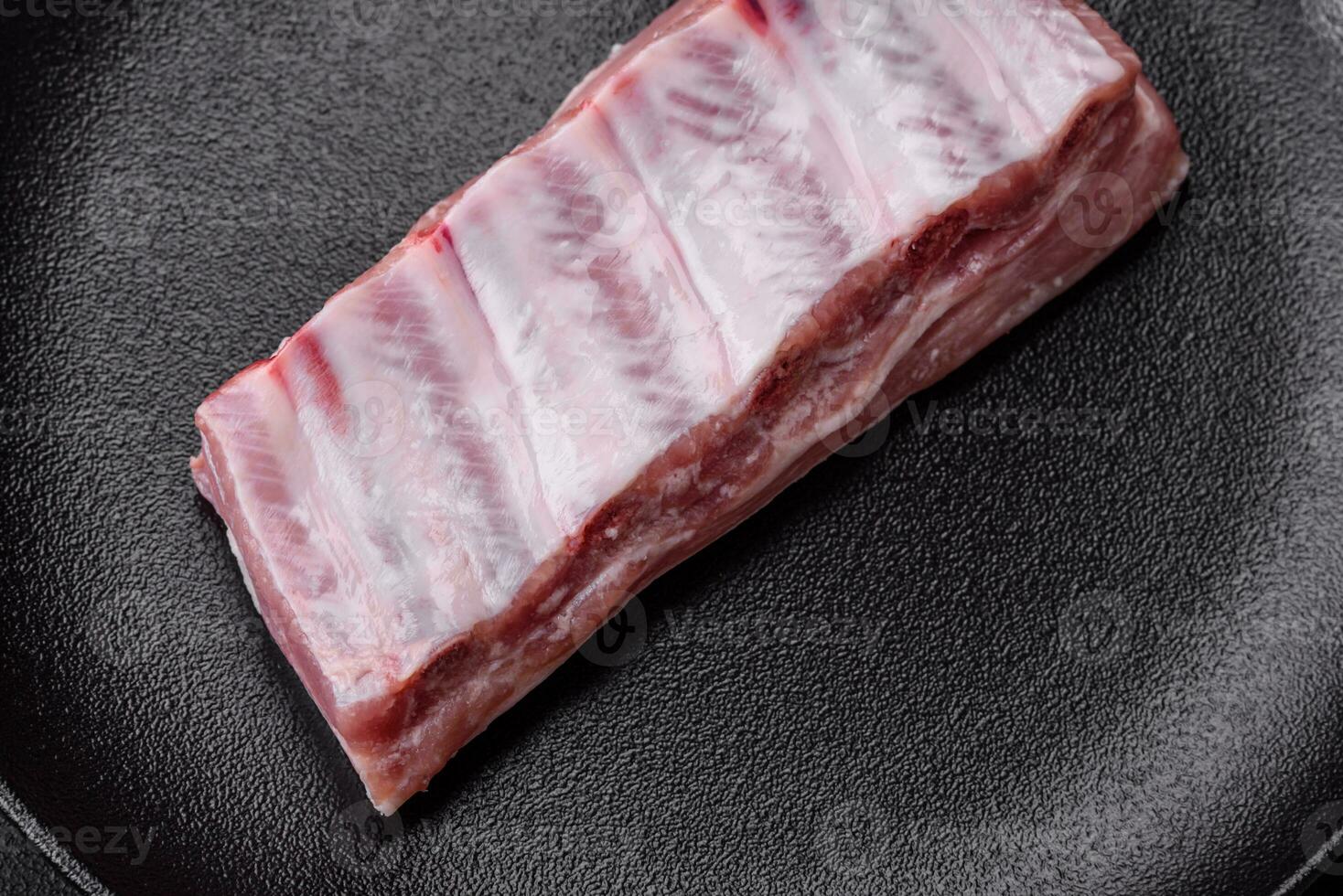 cru carne de porco costelas com carne com sal, especiarias e ervas foto