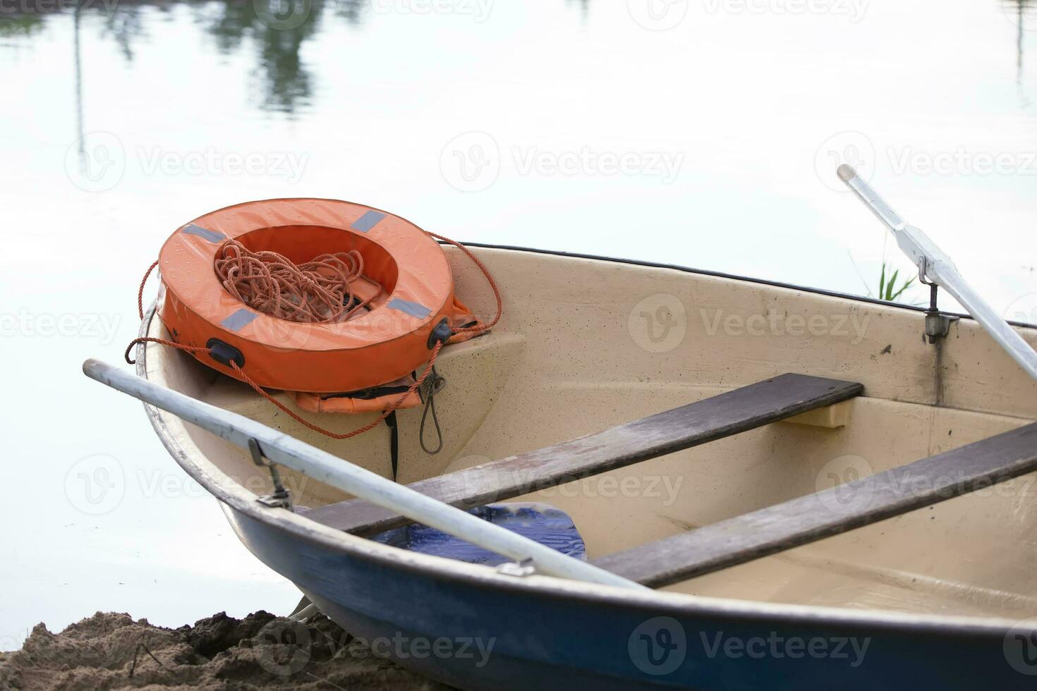 rio barco com remos e a laranja vida anel em a água. foto