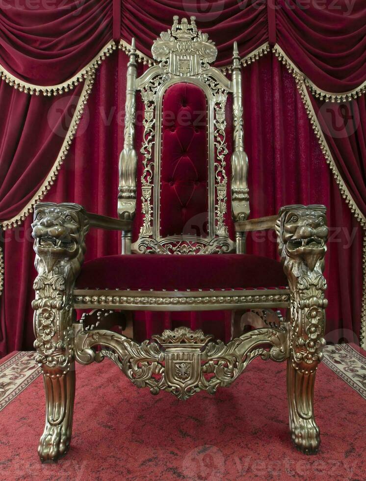 vermelho real cadeira em uma fundo do vermelho cortinas. Lugar, colocar para a rei. trono foto