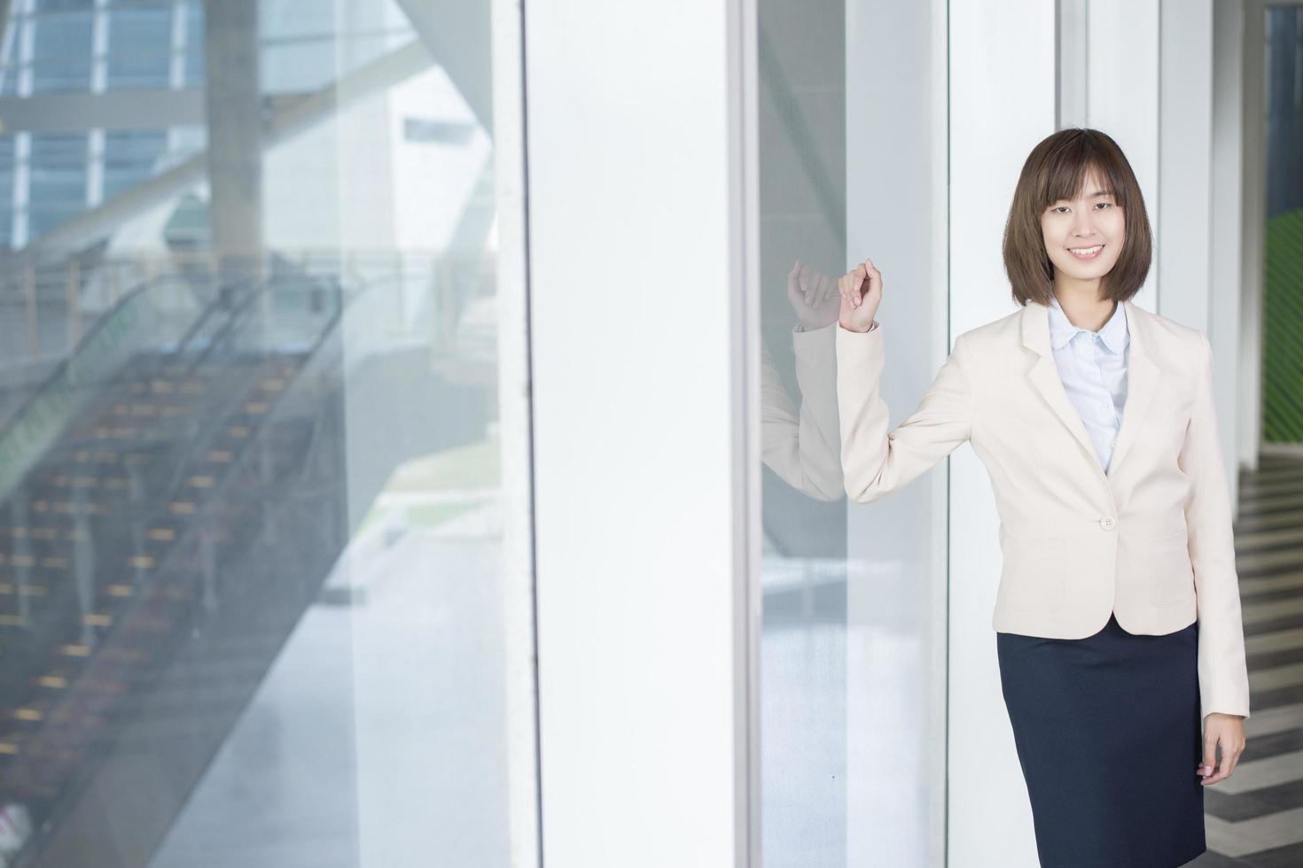 Mulher de negócios asiática atraente sorrindo fora do escritório foto