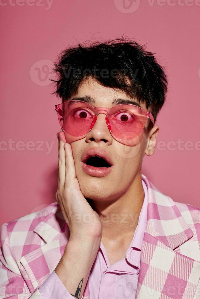 retrato do uma jovem homem dentro Rosa óculos Rosa blazer posando estúdio Rosa fundo inalterado foto