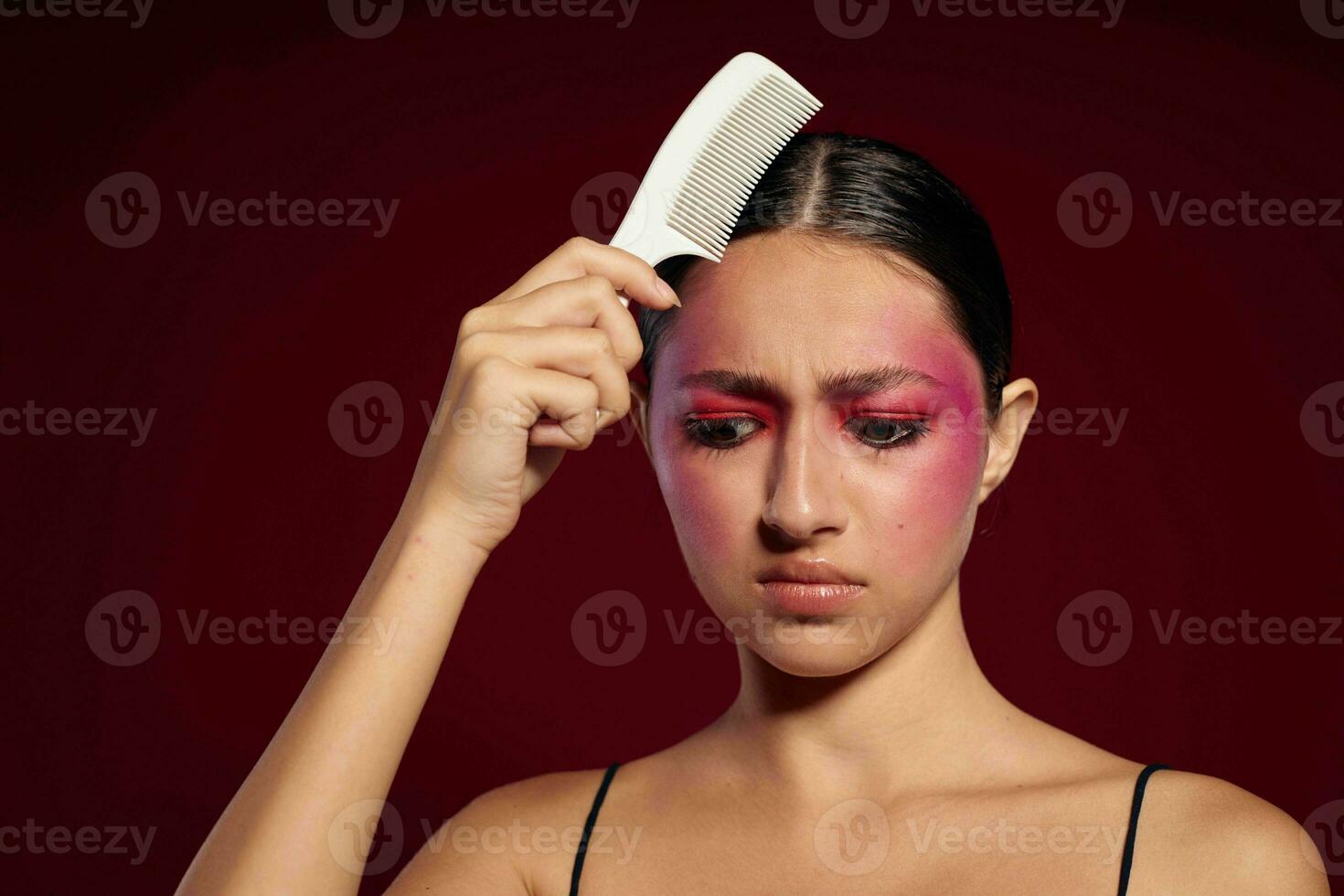 atraente mulher com brilhante Maquiagem pentear dela cabelo pessoal Cuidado foto