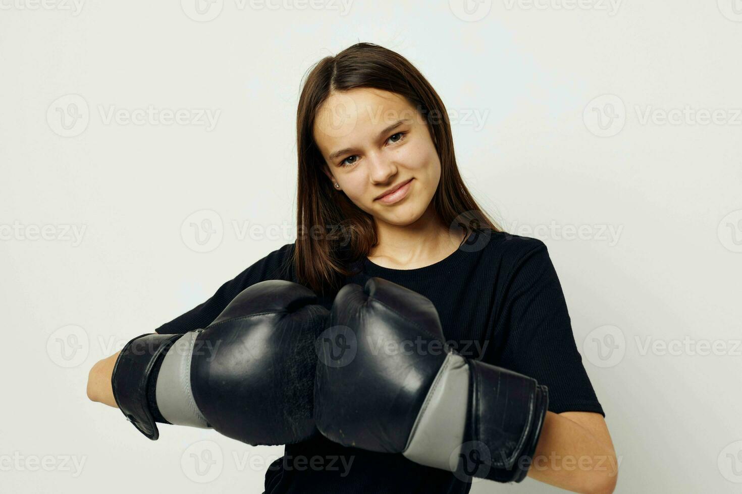 jovem mulher dentro Preto Esportes uniforme boxe luvas posando estilo de vida inalterado foto