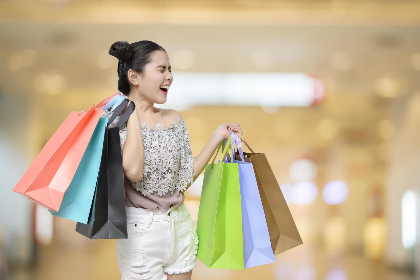 mulher compradora atraente segurando sacolas de compras foto