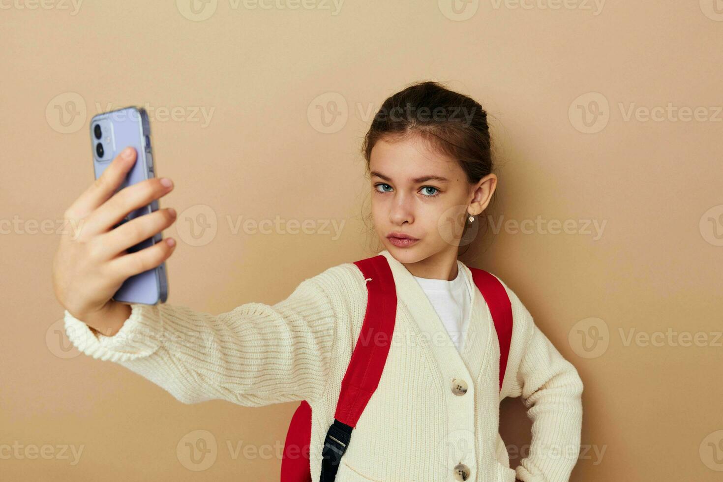 bonita jovem menina estudante mochila telefone dentro mão infância inalterado foto