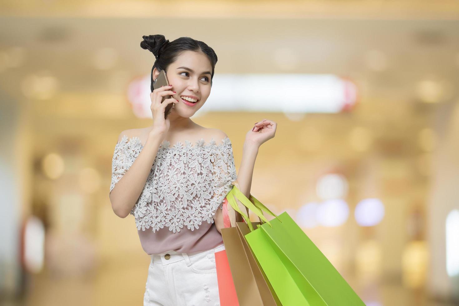 mulher compradora atraente segurando sacolas de compras foto