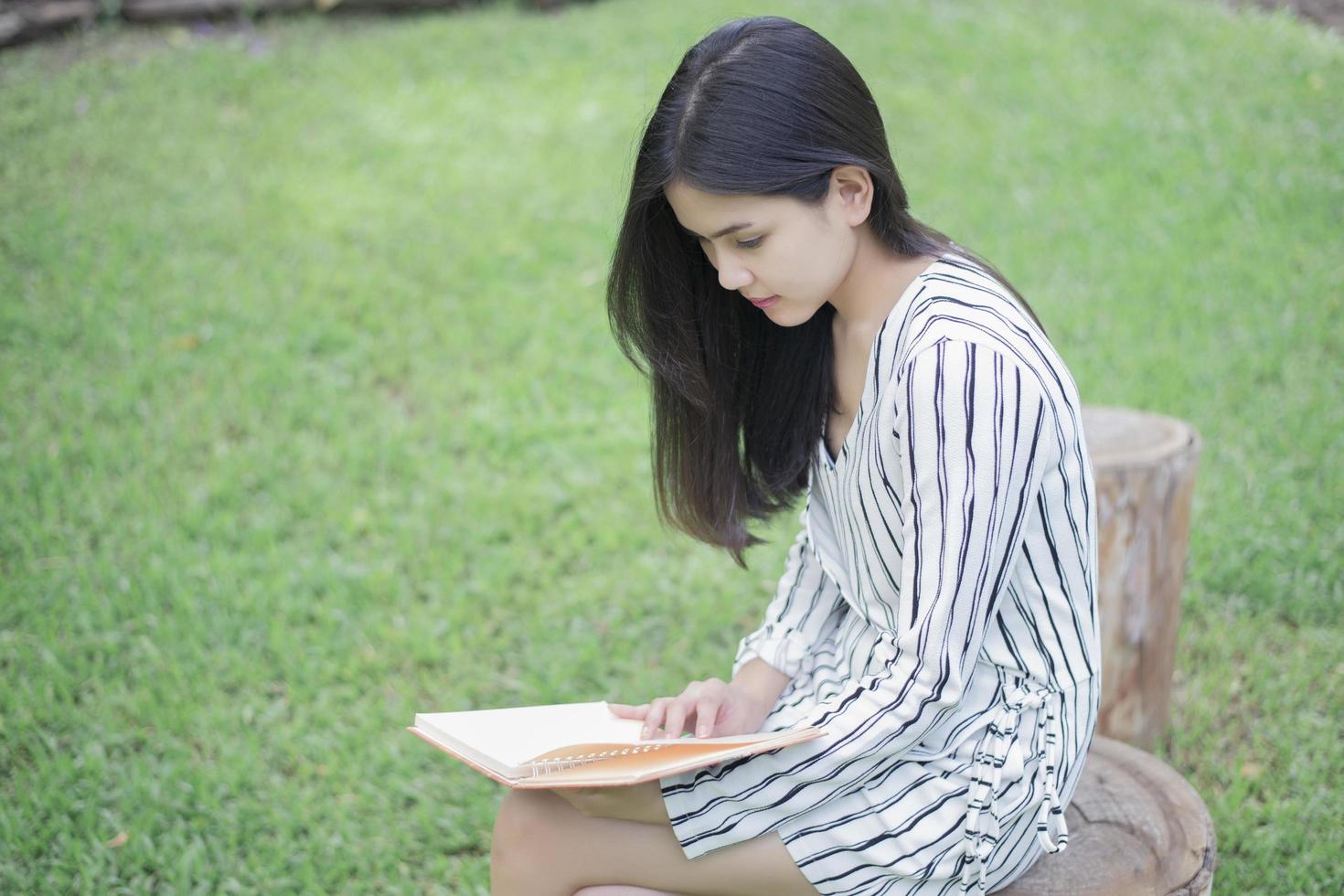 mulher atraente lendo um livro no parque foto