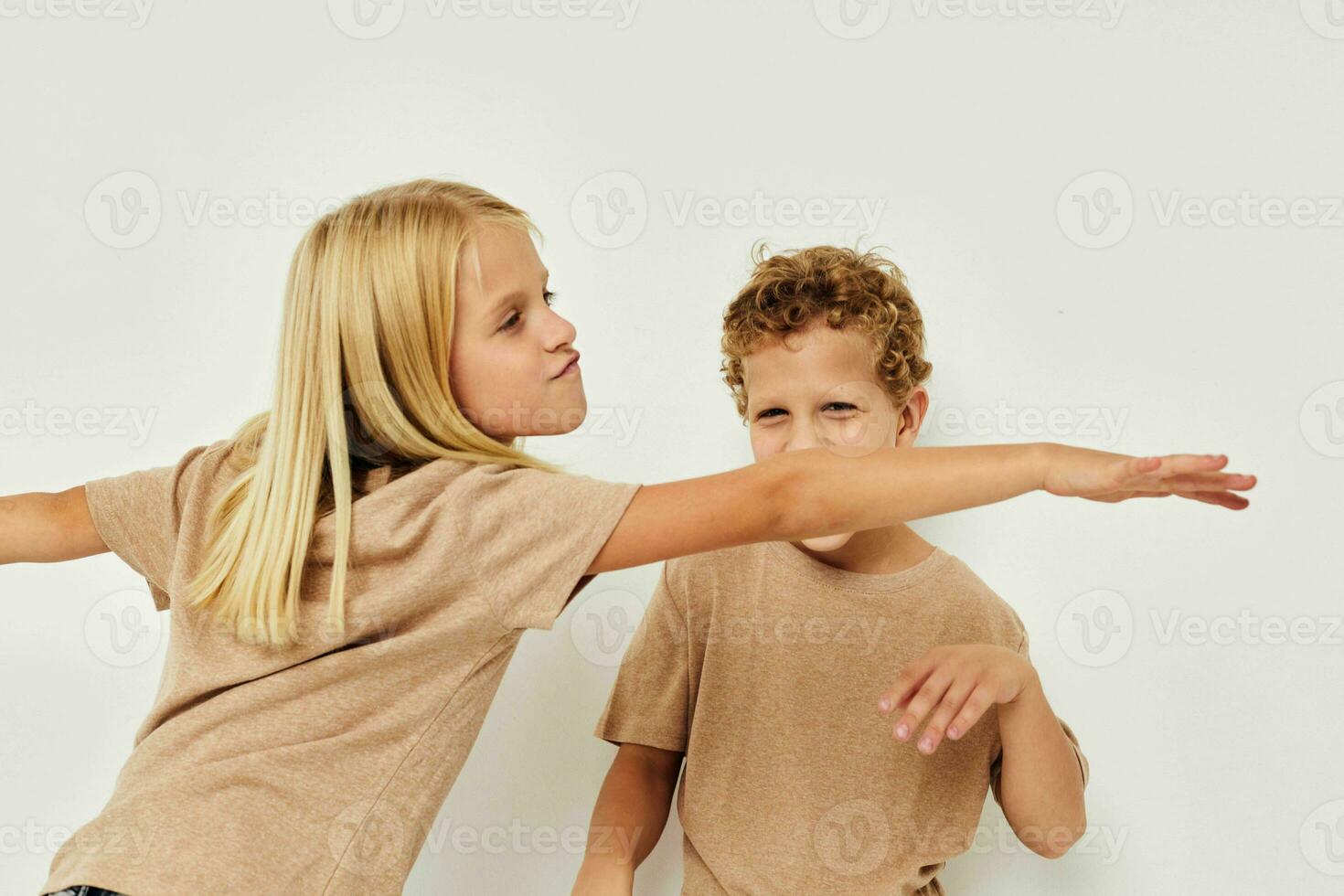 retrato do fofa crianças dentro bege Camisetas posando para Diversão isolado fundo foto