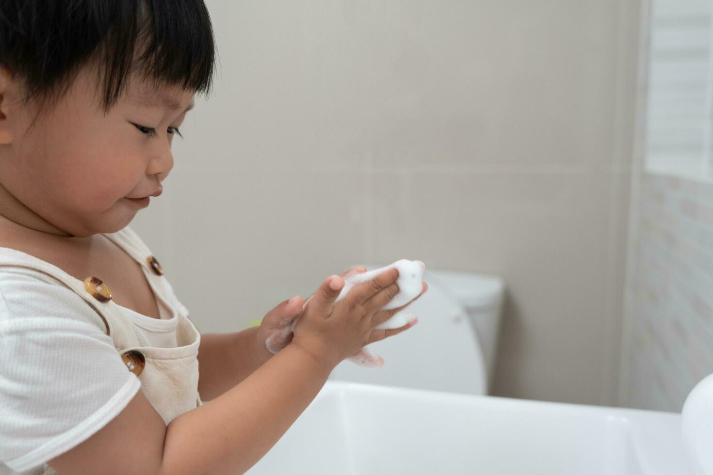 pequeno criança mãos lavar com Sabonete bolhas e enxaguar com limpar \ limpo água para evita e Pare a espalhar do germes depois de costas para lar, vírus ou COVID-19. Boa saúde e Boa pessoal higiene, vírus, bactérias foto