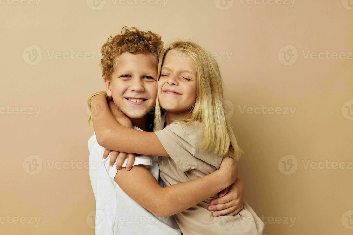 Garoto e menina dentro Camisetas abraços bege fundo amizade foto