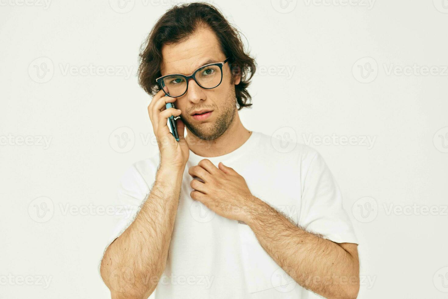 alegre homem dentro uma branco camiseta comunicação de telefone isolado fundo foto