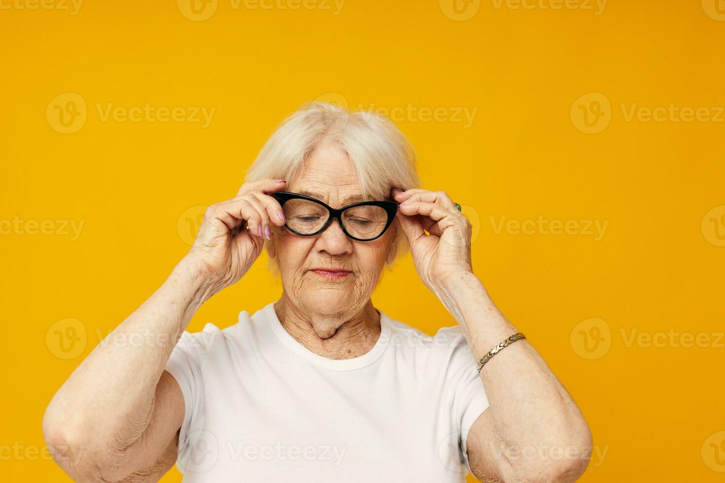 idosos mulher dentro uma branco camiseta desgasta óculos amarelo fundo foto