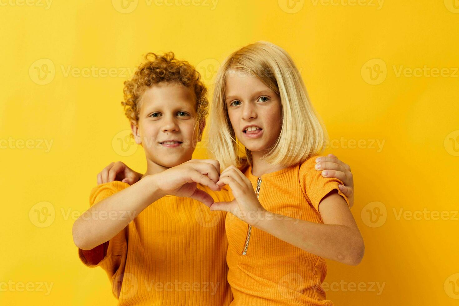 pequeno crianças dentro amarelo Camisetas em pé lado de lado infância emoções amarelo fundo foto