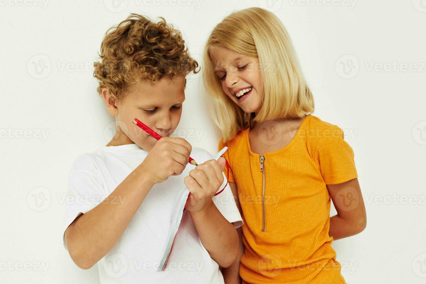 Garoto e menina Diversão dentro colorida Camisetas com uma bloco de anotações isolado fundo inalterado foto