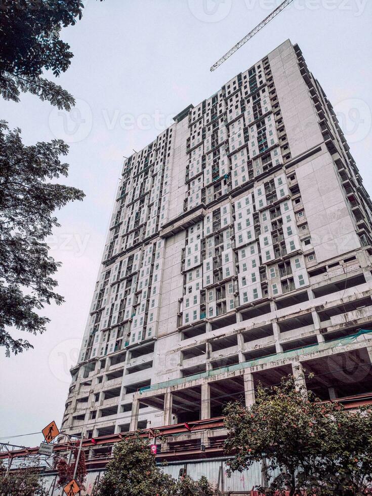 construção inacabada e guindastes de construção contra o fundo claro do céu azul foto